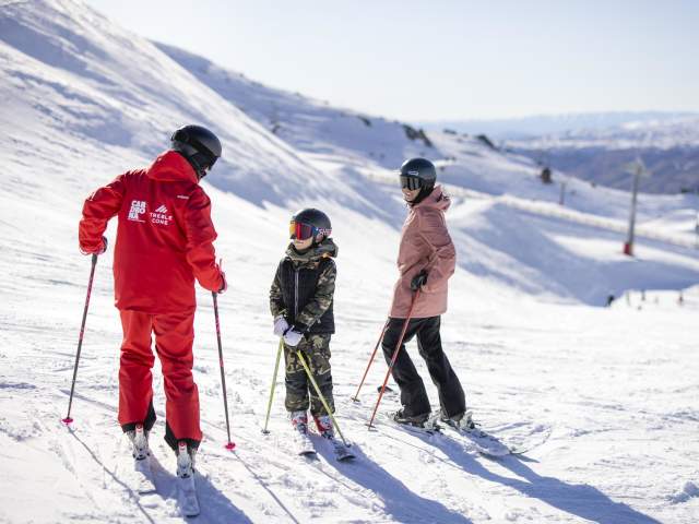 Mother and son having a ski lesson on a snowy mountain