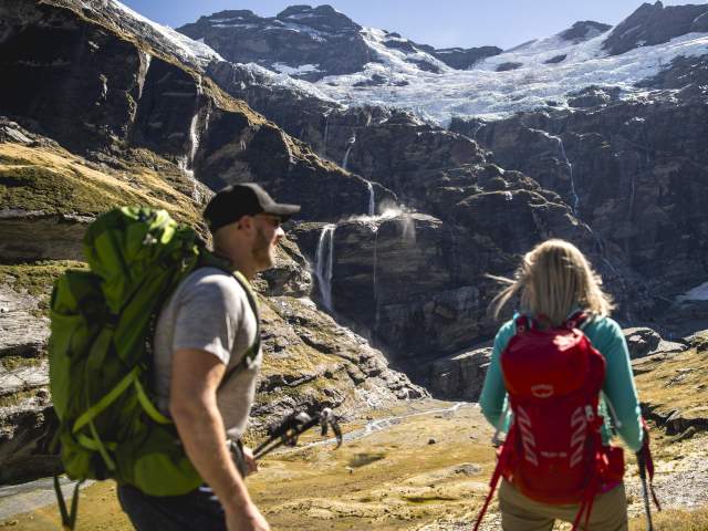 Couple hiking underneath glacier at Earnslaw Burn