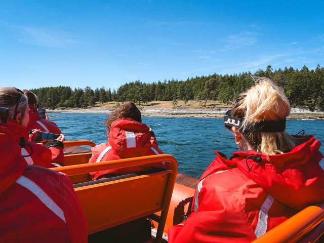 A group of people on a boat sailing by an island.