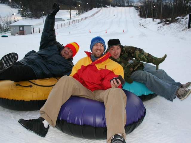 Friends enjoy riding the slopes of Roundtop  Mountain in inflatable tube sleds.