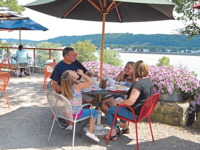 A family eats lunch at a local restaurant overlooking a river.