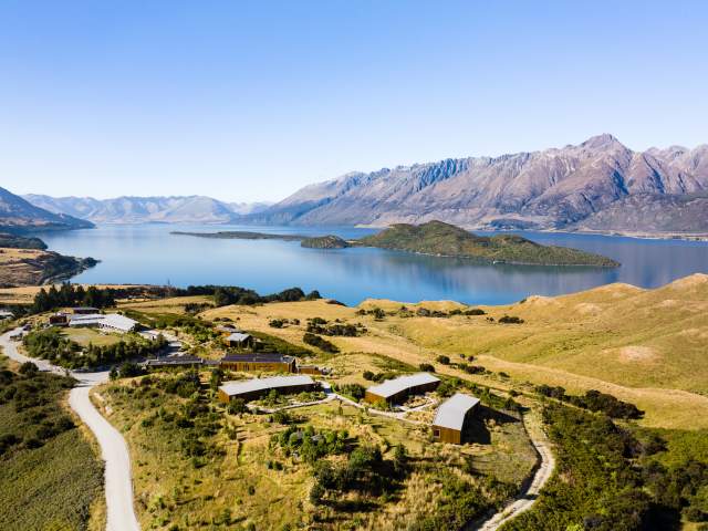 Aerial view of Aro Ha Wellness Retreat with blue lake and dramatic mountains in the background
