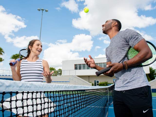 A couple playing tennis at the USTA facilities near the Lake Nona Wave Hotel