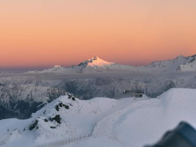 Colourful pink and orange sunrise over snow capped peaks