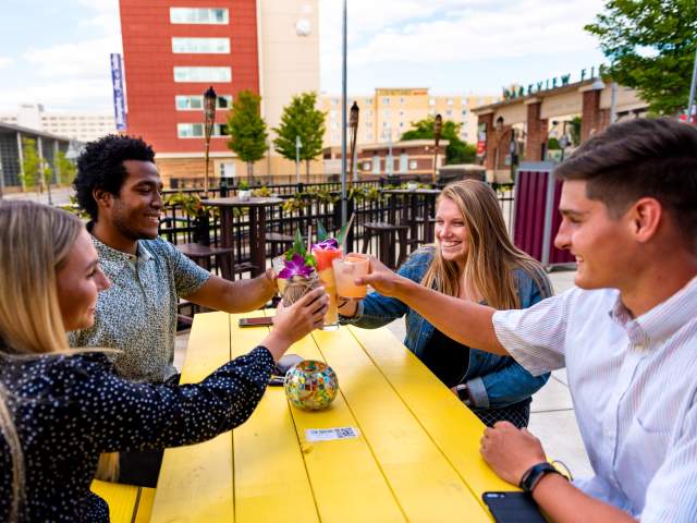 Young adults enjoying drinks at the Sidecar outdoor bar in downtown Fort Wayne.