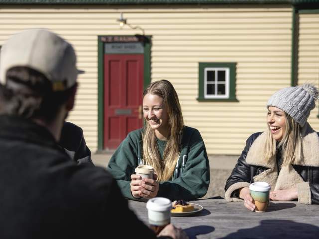 People holding keep cups outside The Boat Shed Cafe and Bistro