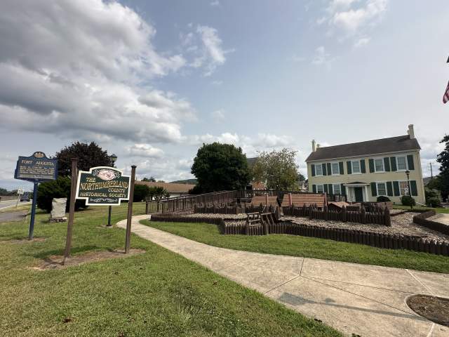 Exterior view of the Northumberland County Historical Society grounds, featuring a historic house, fenced garden area, and museum signage in Central PA.