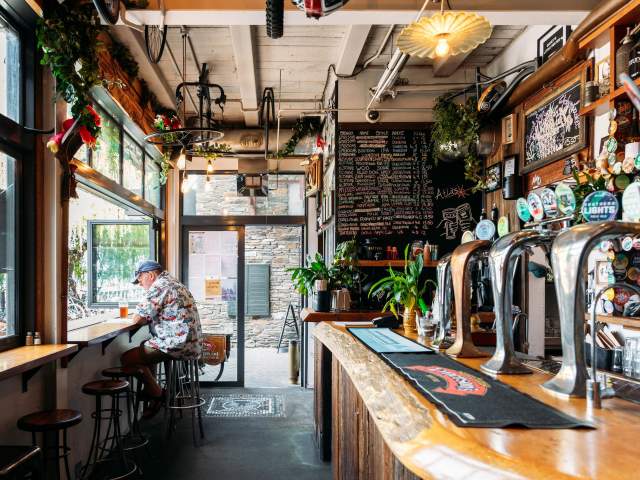 Inside view of Atlas Beer Café with person sitting a high table drinking beer