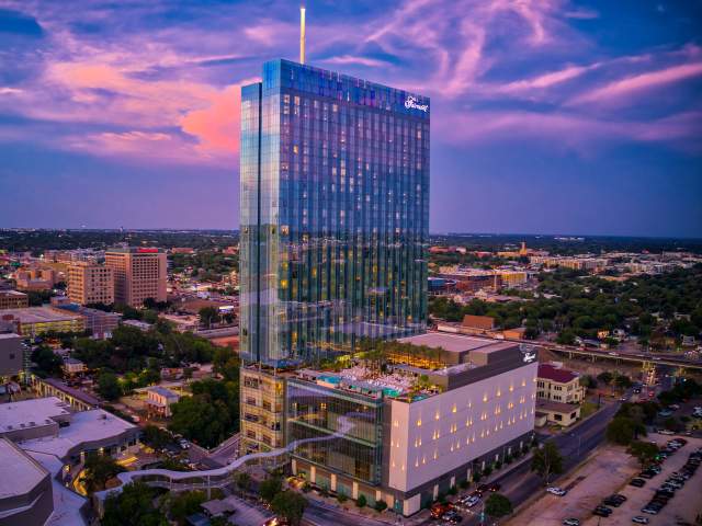 Exterior at sunset with skybridge and rooftop pool at the Fairmont hotel in Austin Texas