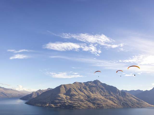 Three paragliders over Cecil Peak