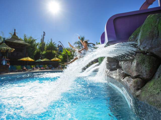 A little girl coming out of a water slide in Universal's Volcano Bay.