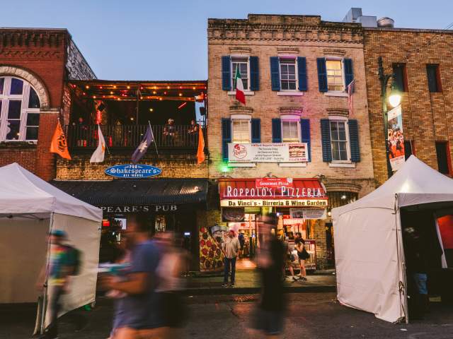people walking down 6th Street in front of Roppolo's Pizzeria and Shakespeare's Pub in Austin Texas