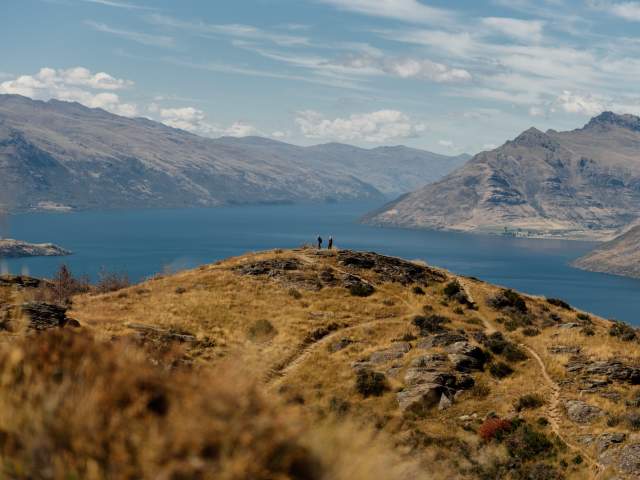 A couple look out towards Lake Whakatipu from Queenstown Hill