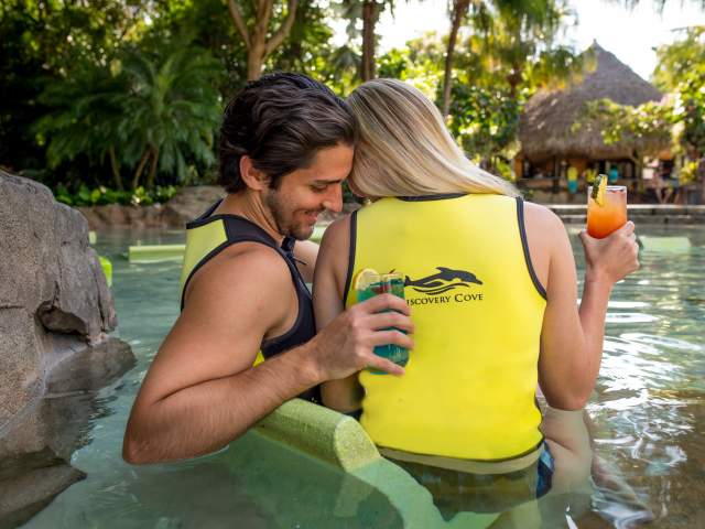 A couple enjoying cocktails at Discovery Cove Sunken Terrace
