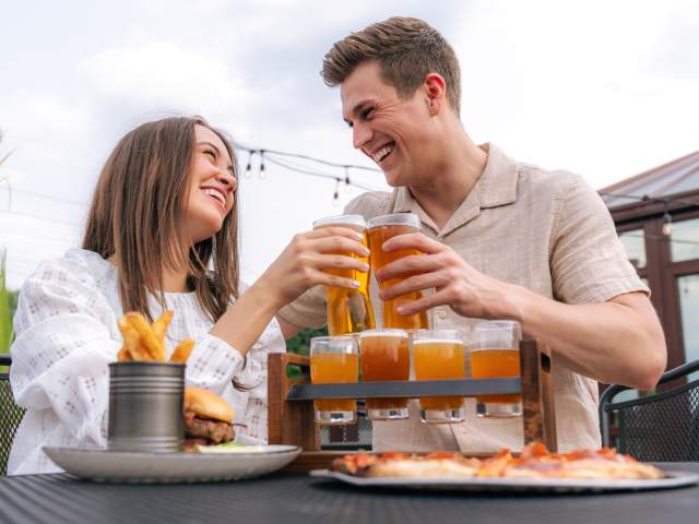 Couple doing a cheers with beer glasses at Grateful Goat.