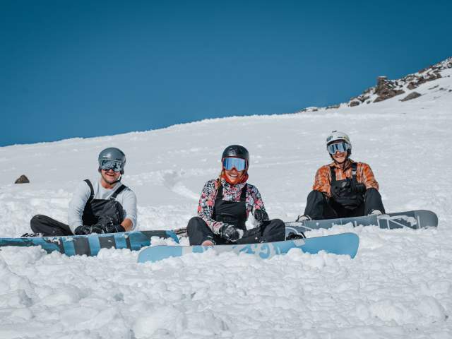 Three Snowboarders at sitting on the slope at The Remarkables