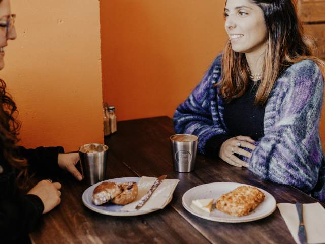 Two people enjoying coffee and scones at Hustl. Café.