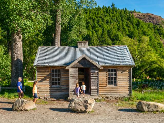 Family in front of the historic Arrowtown Police Hut