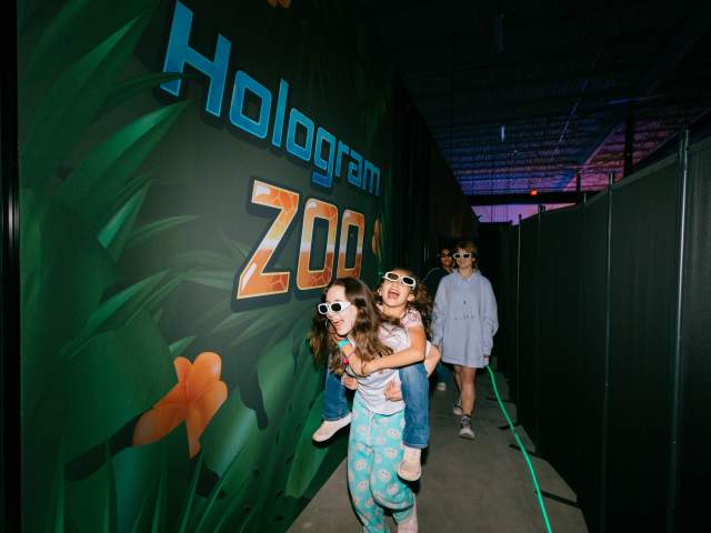 Kids of different ages smiling as they move through the Zoocade.