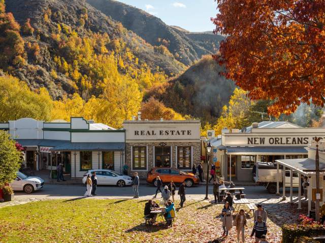 Street view of an old historic town with autumnal trees and mountains in the background