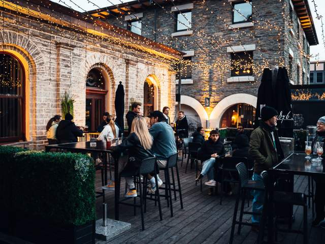 Outside 1876 Bar courtyard covered in pretty fairy lights with people drinking