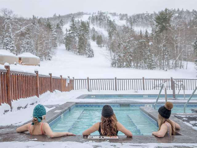 Three women relax at the nordic spa at Mount Bohemia