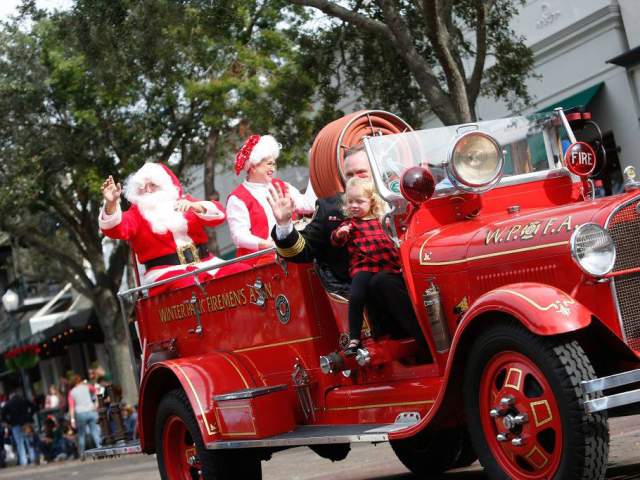 Santa rides a fire truck in the Winter Park Christmas Parade