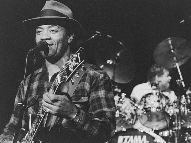 Black and white photo of WC Clark playing guitar and singing