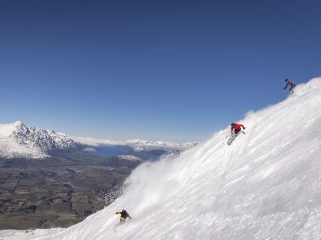 Friends skiing Coronet Peak on a bluebird day