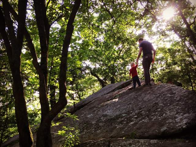 Father and Son Hiking on large rock