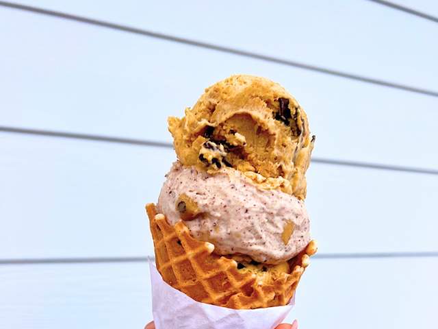 Hand holding an ice cream cone with two scoops of ice cream