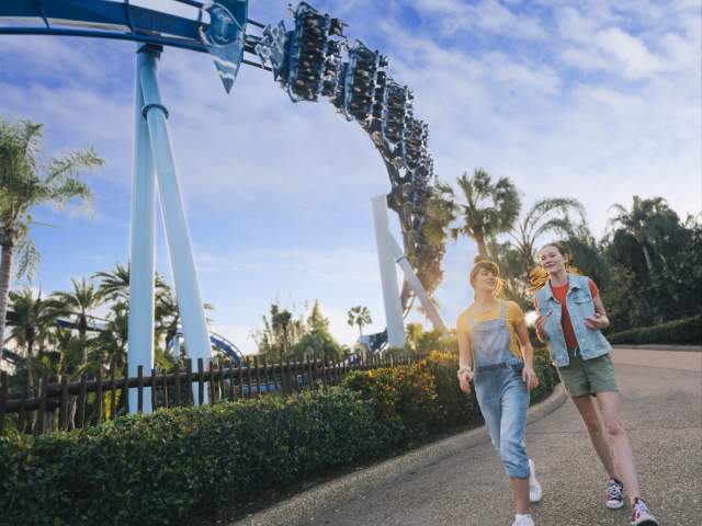 Girls walking past the Manta Rollercoaster at SeaWorld Orlando