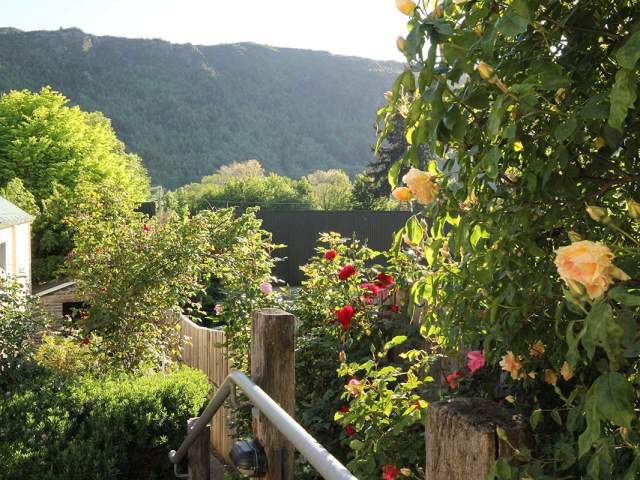 Lush garden with mountain in the background at Arrowtown Lodge