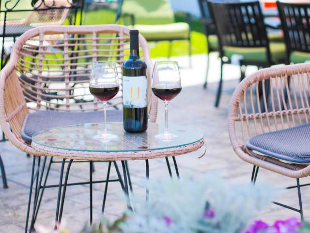 Union Cellars Winery Spring Patio with wine glasses filled next to an open bottle of refreshing wine