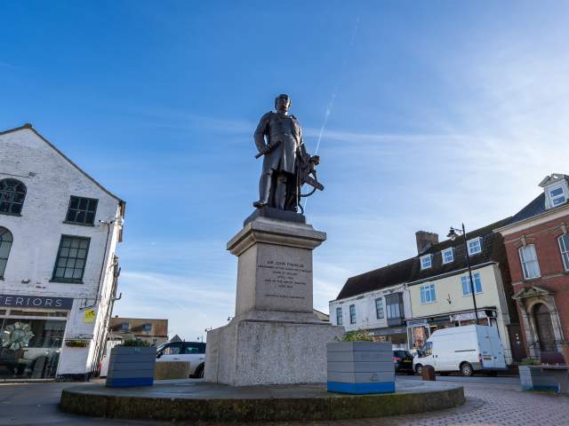a statue of Sir John Franklin in Spilsby town under blue skies