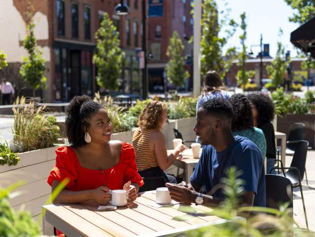 A couple dining outdoors at Utopian Coffee on The Landing in Fort Wayne, Indiana