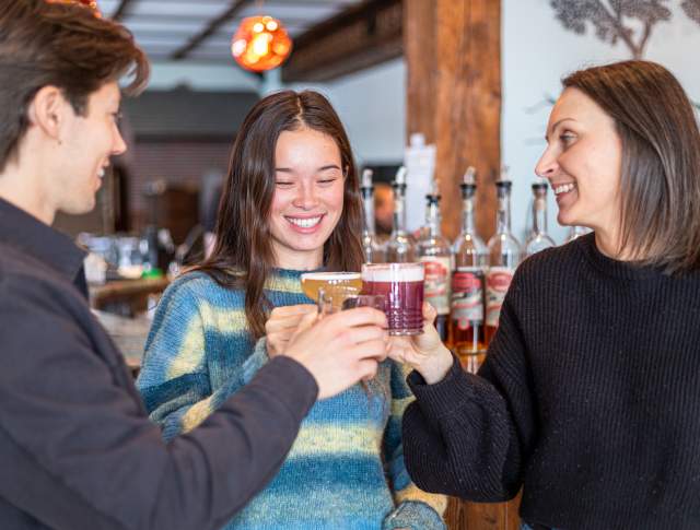 Three friends enjoying a tasting at a distillery