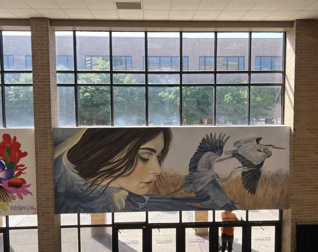 a mural showing a girl being surrounded by herons