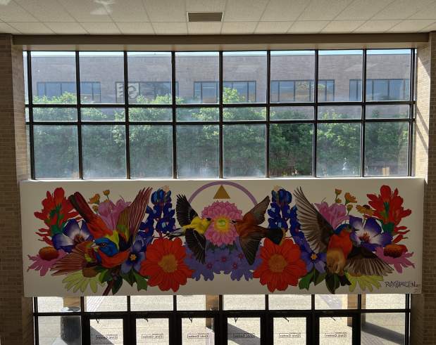 a mural showing birds of prey, flowers, and plants