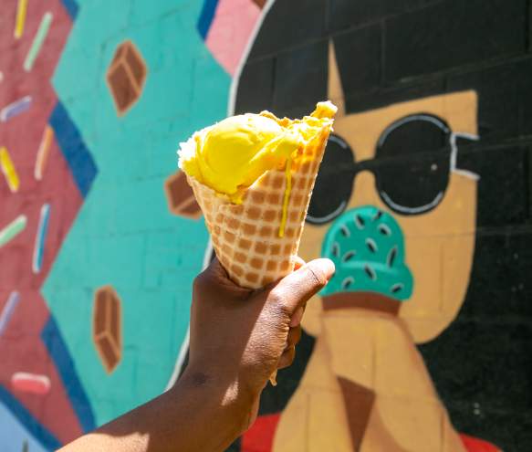 Chocolate Moose ice cream cone held in front of their mural