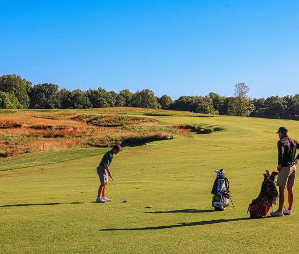 Two men playing golf at the Pfau Course