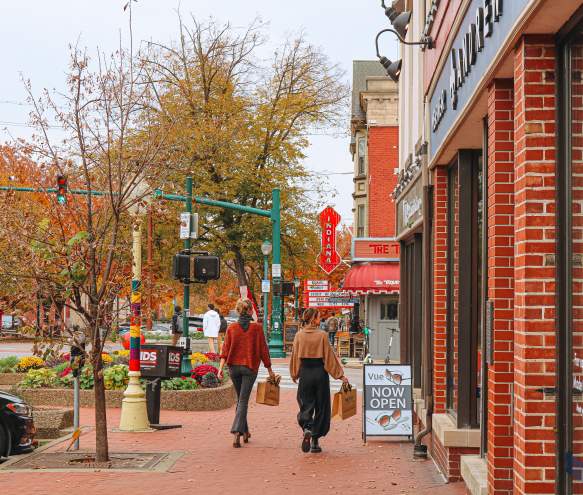 Two women walking with shopping bags toward the Buskirk-Chumley Theater