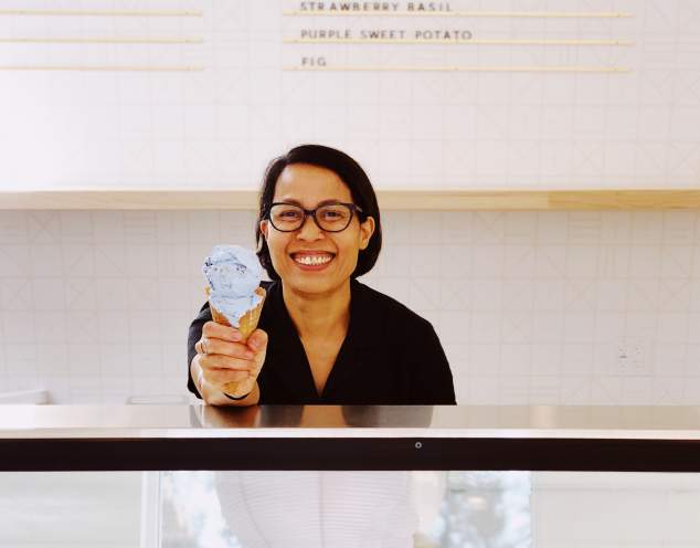 Owner Jam Sanitchat holds a double scoop cone of ice cream inside Gati