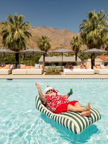 Santa relaxing on a floaty in the pool in Palm Springs
