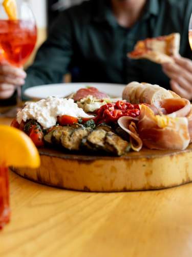 An antipasti board surrounded by Italian cocktails at Bar Corallini