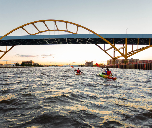 two kayakers kayaking under the Hoan Bridge