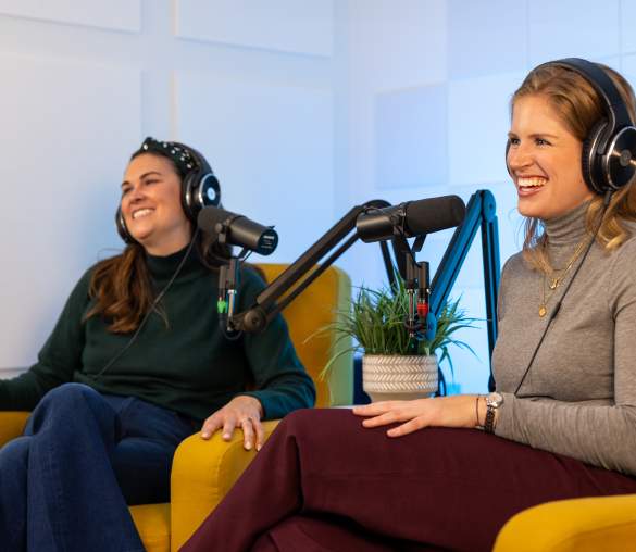 two women with headphones on in podcast studio