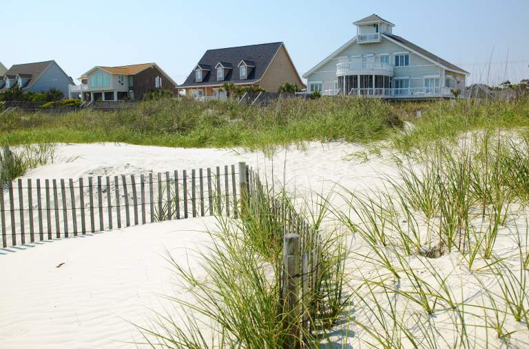 Beach houses sit behind sand dunes in North Myrtle Beach