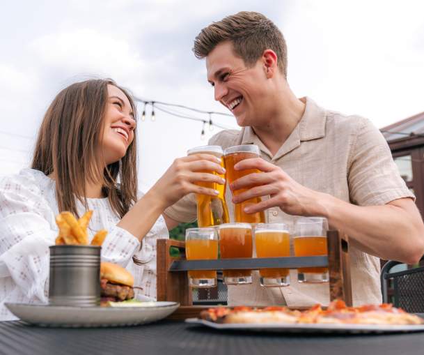 Couple doing a cheers with beer glasses at Grateful Goat.