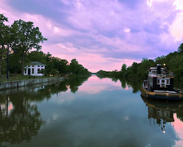 Erie Canal at sunset, with a tugboat on the water